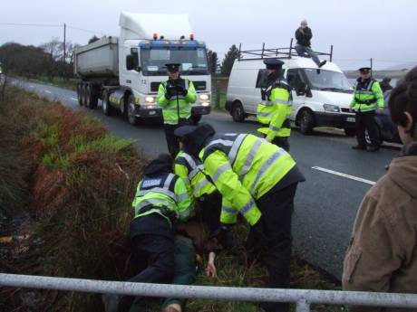 Person being held down in the brambles while Shell's convoy passes