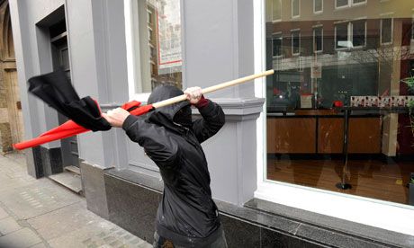 protester tries to break a window in Oxford Street during the anti-cuts march